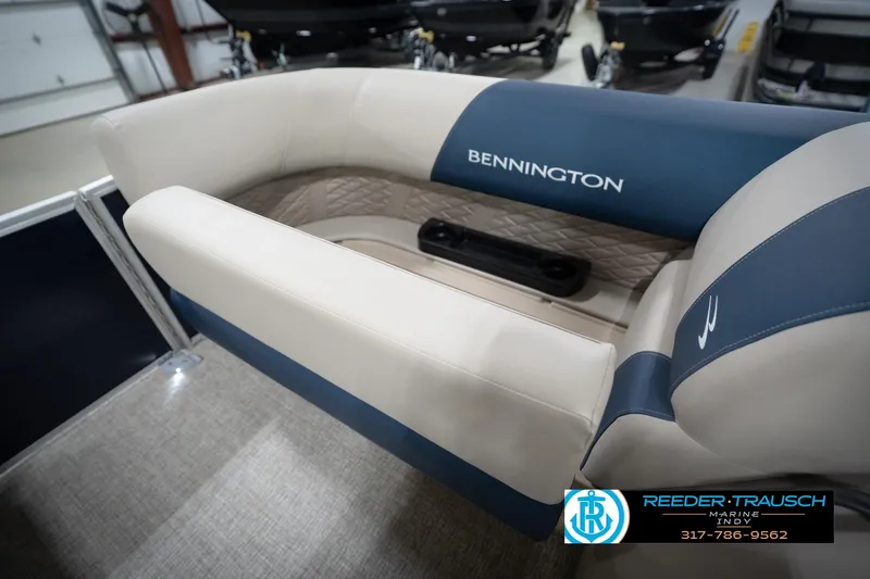 Slide: The Image of 2026 Bennington 168 SLJ boat interior with beige and blue seating, showroom display. - 25