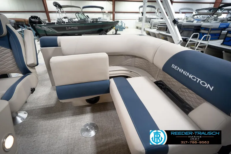 Slide: The Image of 2026 Bennington 168 SLJ boat interior with beige and blue seating in showroom. - 30