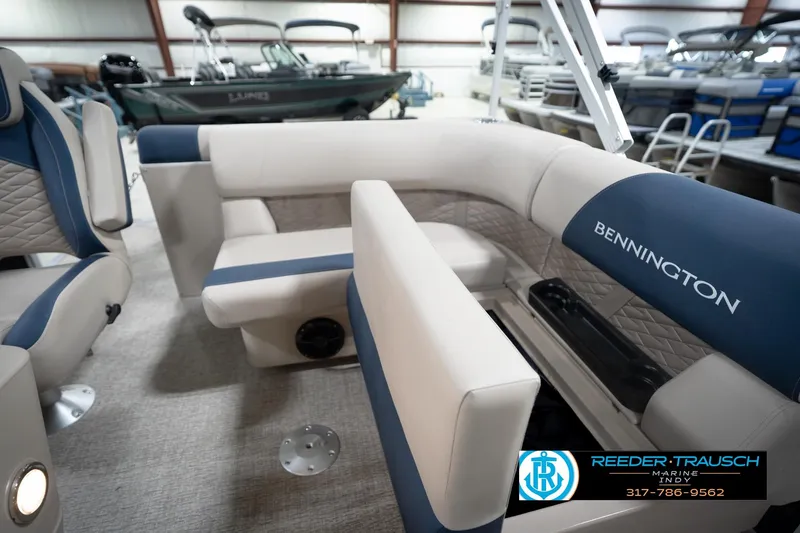 Slide: The Image of 2026 Bennington 168 SLJ boat interior with blue and beige seating in showroom. - 31