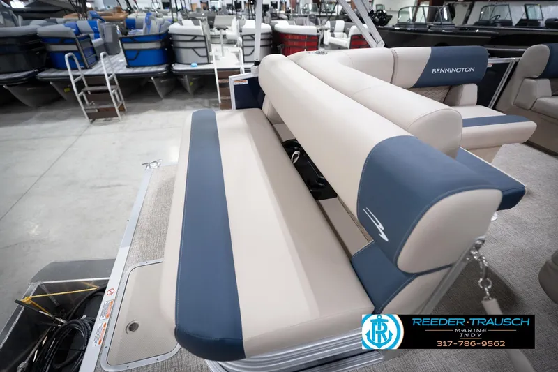 Slide: The Image of 2026 Bennington 168 SLJ boat interior with beige and blue seating in showroom. - 32