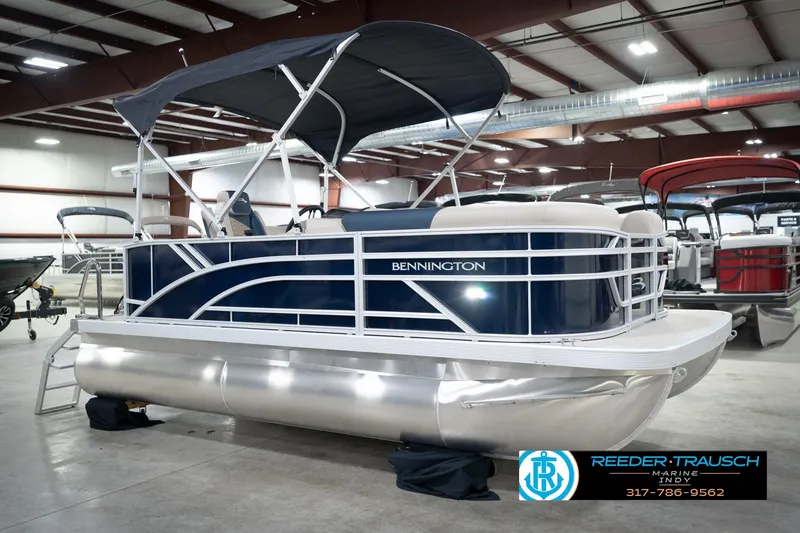 Slide: The Image of 2026 Bennington 168 SLJ pontoon boat in showroom, featuring blue and white design. - 6