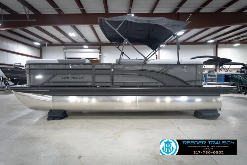 Slide: The Image of 2026 Bennington 21 SL pontoon boat in showroom with canopy and sleek design. - 11