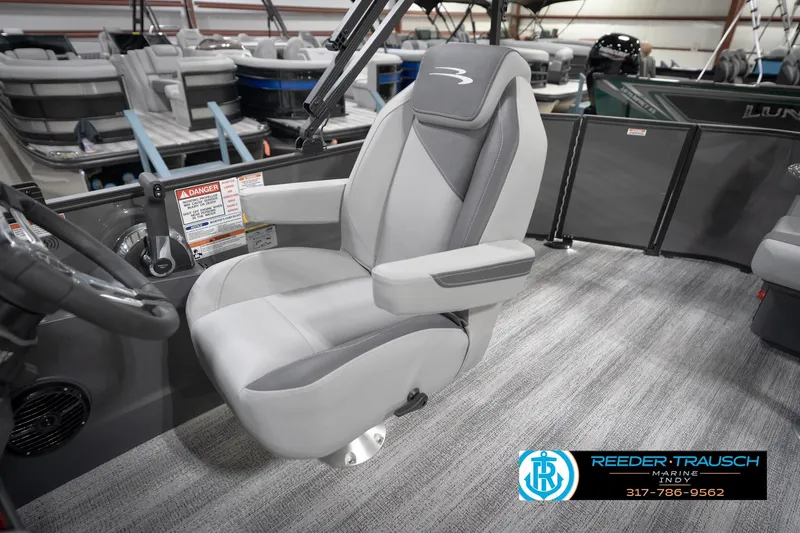 Slide: The Image of 2026 Bennington 21 SL boat interior with gray captain's chair and steering wheel. - 29