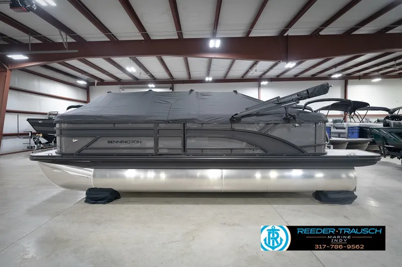 Slide: The Image of 2026 Bennington 21 SL pontoon boat in showroom with protective cover. - 56