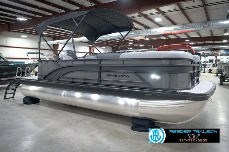 Slide: The Image of 2026 Bennington 21 SL pontoon boat in showroom with canopy and sleek design. - 6