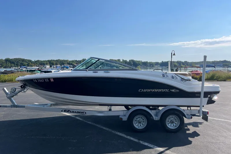 Slide: The Image of 2013 Chaparral 206 SSi boat on trailer, parked near a scenic waterfront. - 3