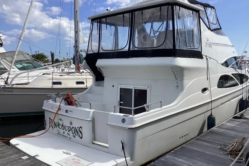 The Image of 2005 Carver 41 Cockpit Motor Yacht docked at marina under blue sky. - 0