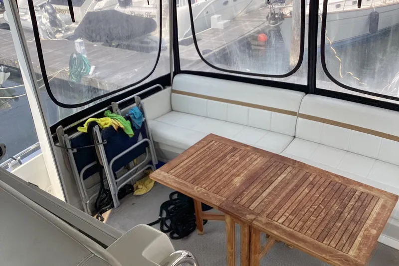 Slide: The Image of 2005 Carver 41 Cockpit Motor Yacht interior with wooden table and white seating. - 10