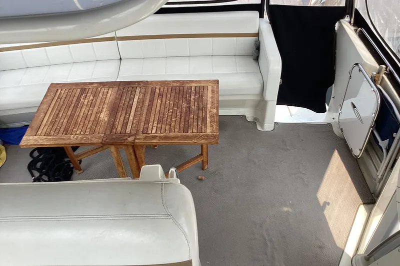 Slide: The Image of 2005 Carver 41 Cockpit Motor Yacht interior with white seating and wooden table. - 11
