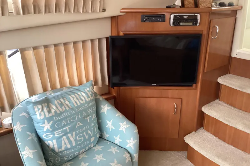 Slide: The Image of Interior of 2005 Carver 41 Cockpit Motor Yacht with TV, chair, and stairs. - 16