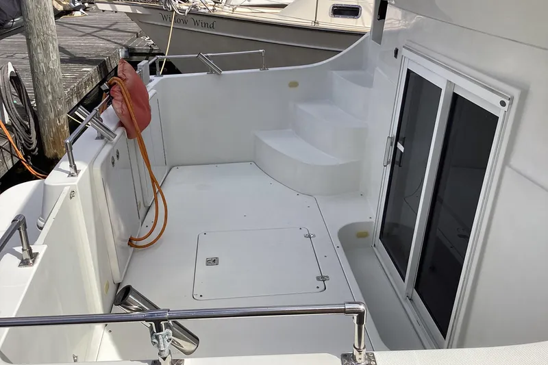 Slide: The Image of 2005 Carver 41 Cockpit Motor Yacht, spacious deck with sliding doors and dock view. - 22