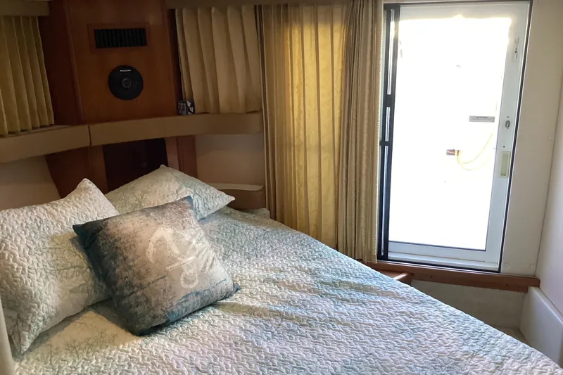 Slide: The Image of Cozy bedroom in 2005 Carver 41 Cockpit Motor Yacht with elegant bedding and natural light. - 46