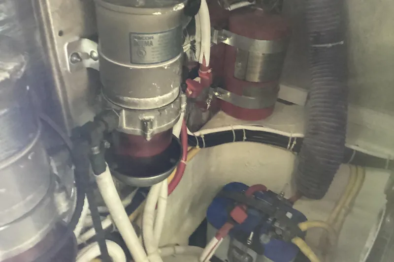 Slide: The Image of Engine room of 2005 Carver 41 Cockpit Motor Yacht with visible fuel filters and hoses. - 52