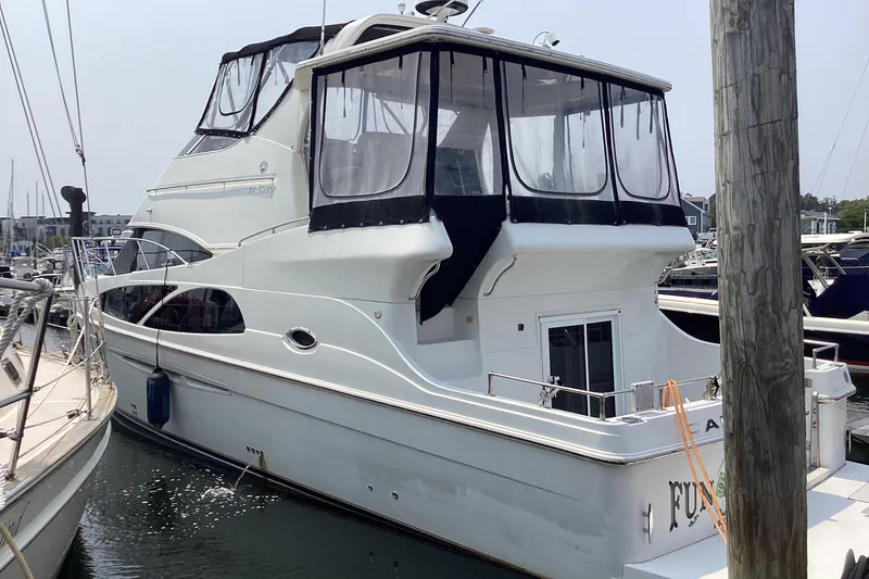 Slide: The Image of 2005 Carver 41 Cockpit Motor Yacht docked at marina, featuring spacious upper deck. - 2