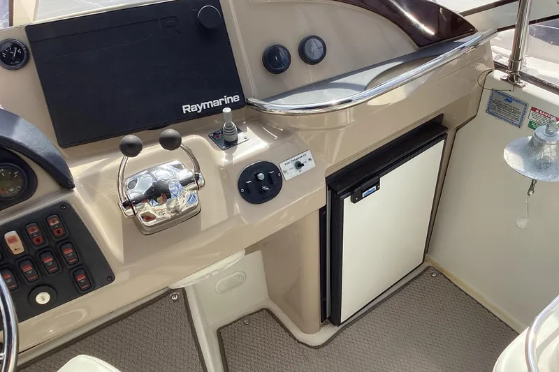 Slide: The Image of 2005 Carver 41 Cockpit Motor Yacht helm with Raymarine controls and mini fridge. - 24
