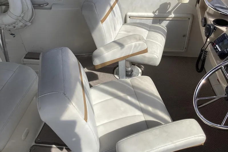 Slide: The Image of 2005 Carver 41 Cockpit Motor Yacht interior with white leather seats and steering wheel. - 31