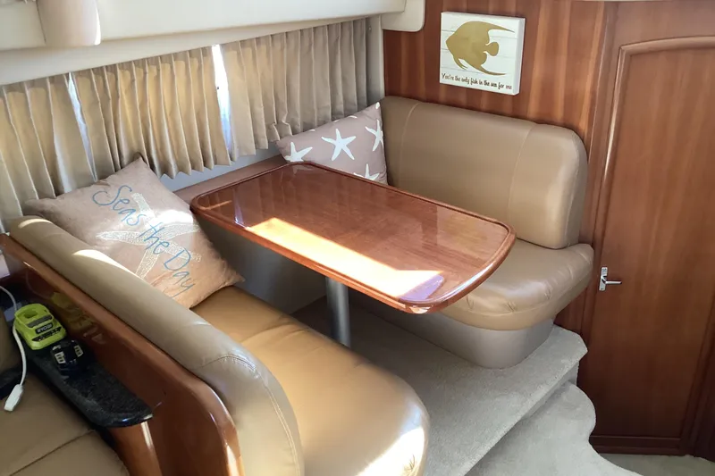 Slide: The Image of 2005 Carver 41 Cockpit Motor Yacht interior with cozy dining area and decorative pillows. - 33