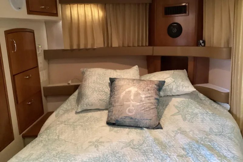 Slide: The Image of Interior of 2005 Carver 41 Cockpit Motor Yacht bedroom with cozy bedding and wooden cabinetry. - 45