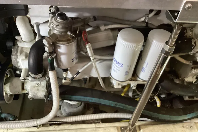 Slide: The Image of Engine compartment of 2005 Carver 41 Cockpit Motor Yacht with visible filters and hoses. - 49