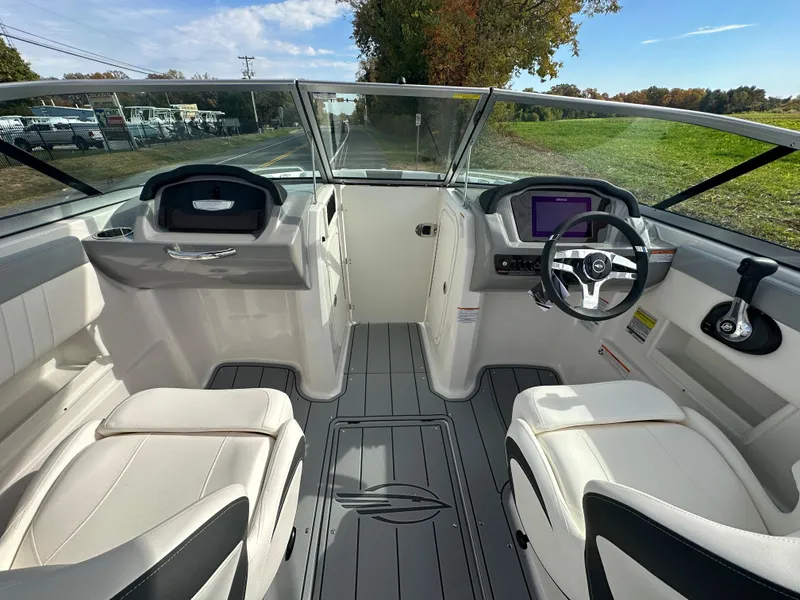 Slide: The Image of 2024 Chaparral 23 SSi boat interior with dual captain's chairs and modern dashboard. - 12