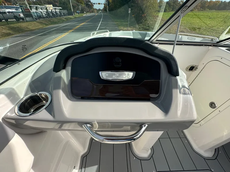 Slide: The Image of 2024 Chaparral 23 SSi boat dashboard with steering wheel and cup holder. - 14