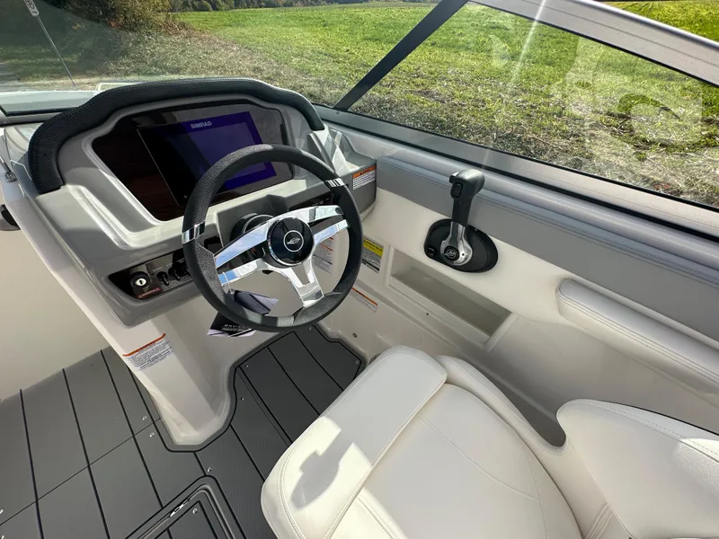 Slide: The Image of 2024 Chaparral 23 SSi boat cockpit with steering wheel and control panel. - 18