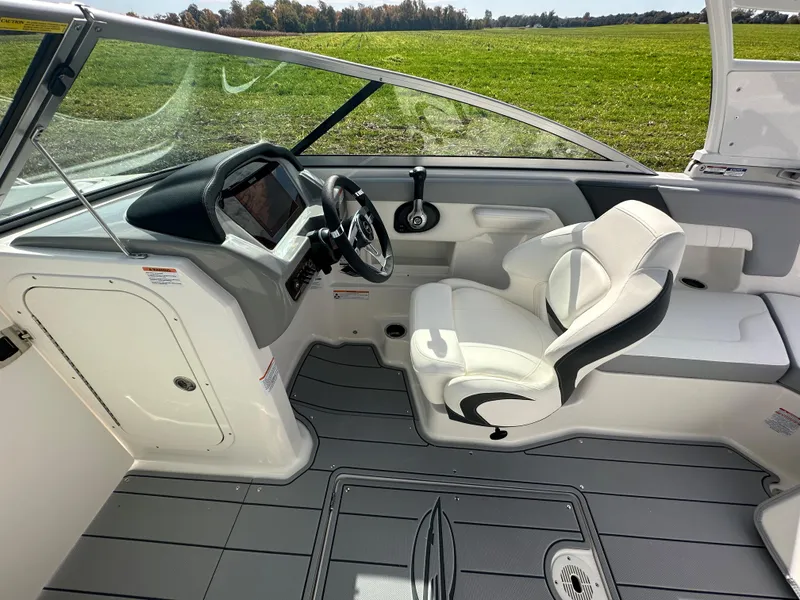 Slide: The Image of 2024 Chaparral 23 SSi boat interior with captain's chair and dashboard. - 19