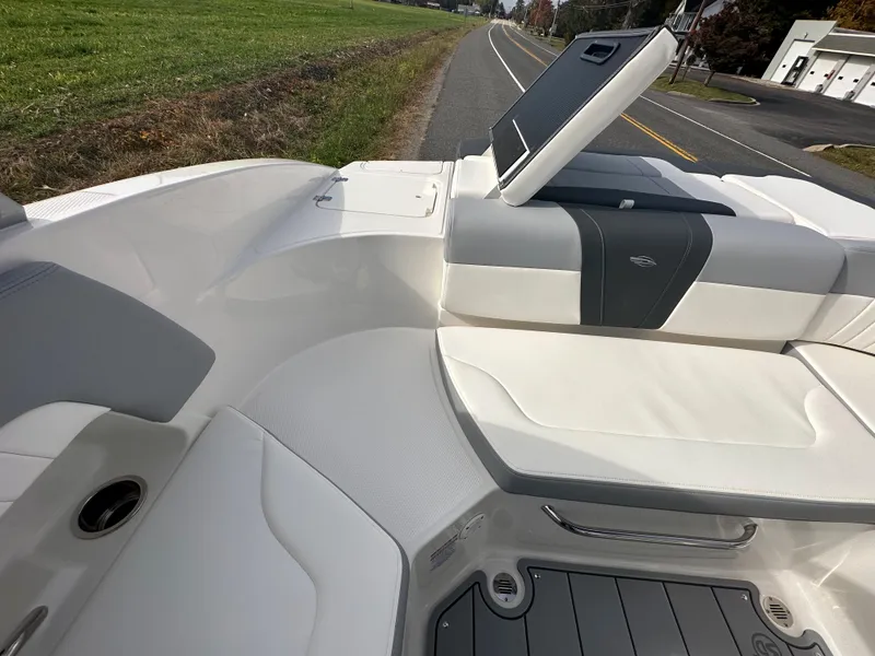 Slide: The Image of 2024 Chaparral 23 SSi boat interior with white seating and storage compartment. - 29