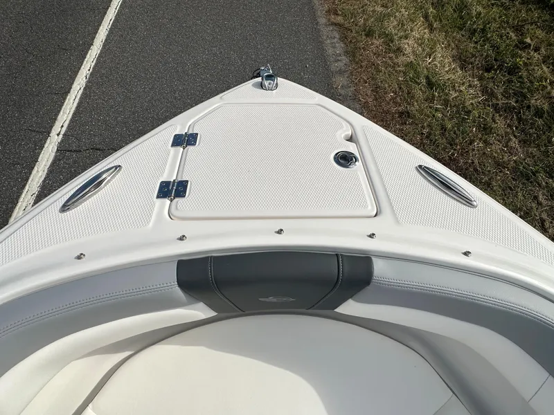 Slide: The Image of 2024 Chaparral 23 SSi boat bow with white upholstery and storage compartment. - 3