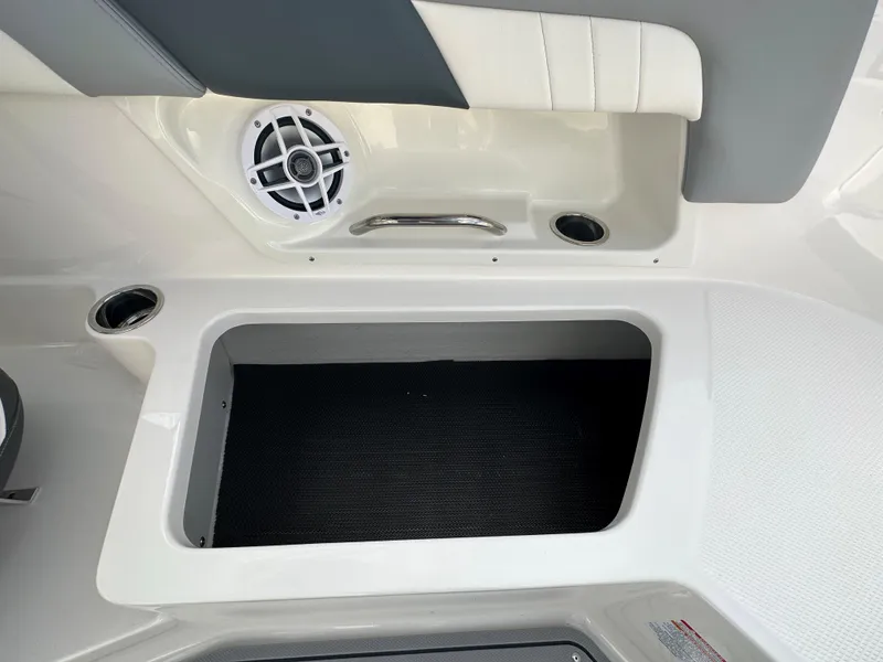 Slide: The Image of 2024 Chaparral 23 SSi boat interior storage compartment with speaker and cup holders. - 30