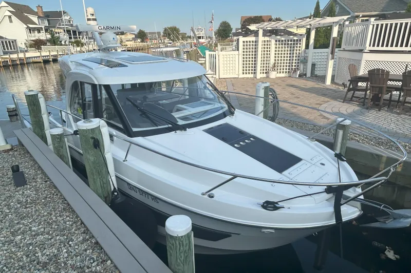 Slide: The Image of 2024 Beneteau Antares 9 docked in a scenic marina setting. - 0