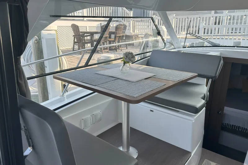 Slide: The Image of 2024 Beneteau Antares 9 interior with dining area, featuring a table and seating. - 11