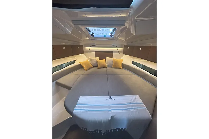 Slide: The Image of 2024 Beneteau Antares 9 cabin interior with cozy bedding and decorative pillows. - 17