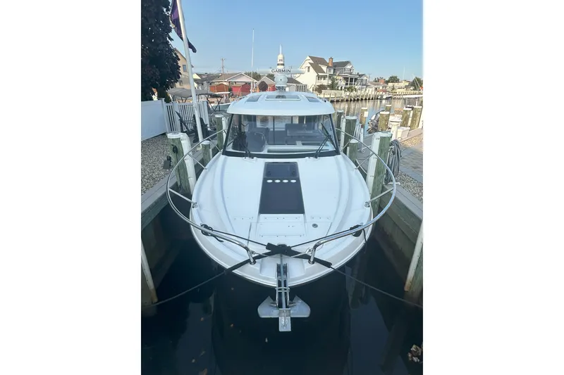 Slide: The Image of 2024 Beneteau Antares 9 docked at a marina, front view. - 2