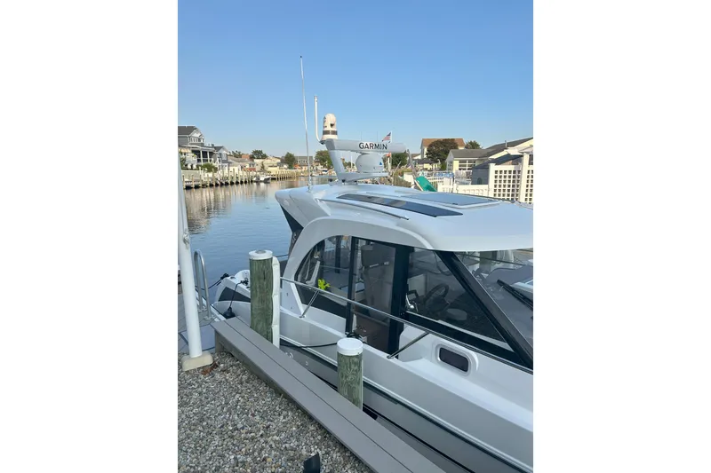 Slide: The Image of 2024 Beneteau Antares 9 docked at a marina, showcasing sleek design and modern features. - 4