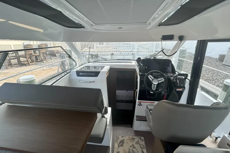 Slide: The Image of Interior view of 2024 Beneteau Antares 9 boat, featuring helm and seating area. - 9