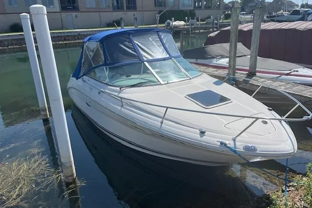 The Image of 2001 Sea Ray 225 Weekender boat docked with blue canopy in marina. - 0