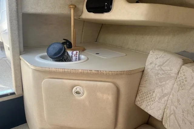 Slide: The Image of Interior of 2001 Sea Ray 225 Weekender boat with beige upholstery and storage area. - 11