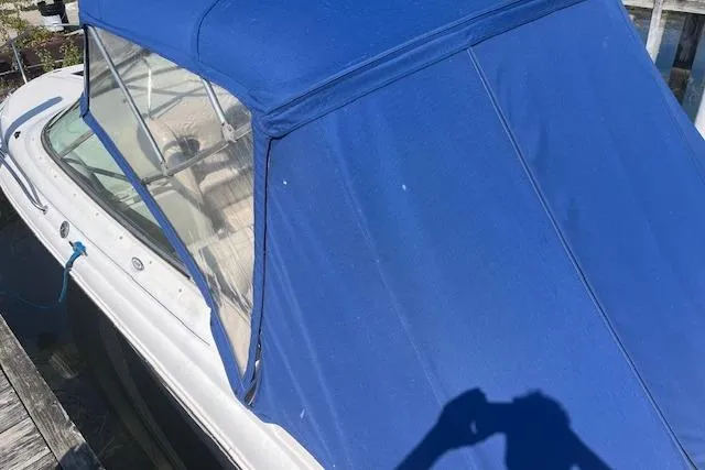 Slide: The Image of 2001 Sea Ray 225 Weekender with blue canvas cover at dock. - 3