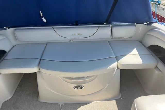 Slide: The Image of 2001 Sea Ray 225 Weekender boat interior with cushioned seating and blue canopy. - 7