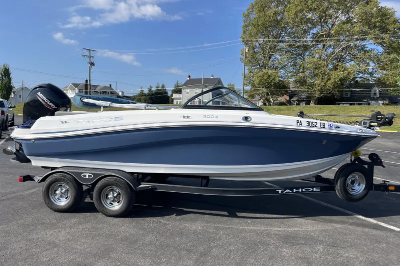 Slide: The Image of 2022 Tahoe 200 S boat on trailer, parked outdoors under clear sky. - 2
