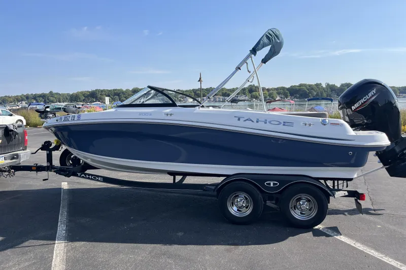 Slide: The Image of 2022 Tahoe 200 S boat on trailer, parked near a lake with clear skies. - 7