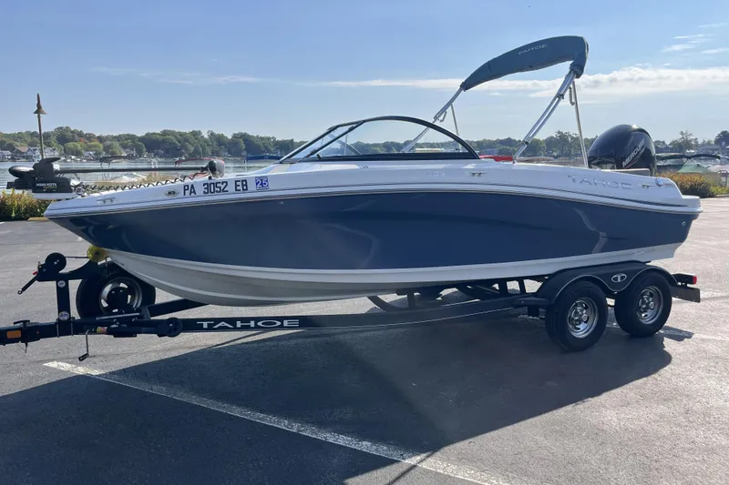 Slide: The Image of 2022 Tahoe 200 S boat on trailer, parked near a scenic waterfront. - 8