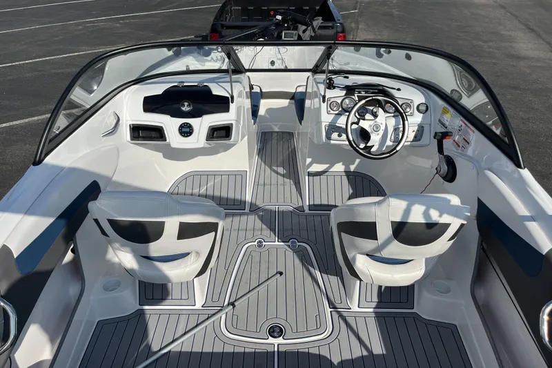 Slide: The Image of 2022 Tahoe 200 S boat interior with steering wheel and seating, parked on asphalt. - 9