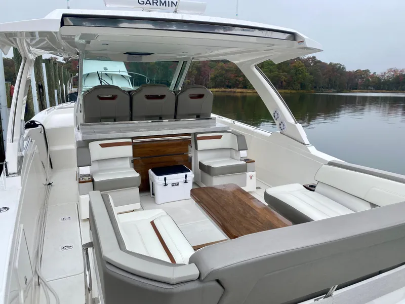 Slide: The Image of 2022 Tiara Yachts 38 LS with spacious seating and elegant design on a calm lake. - 11