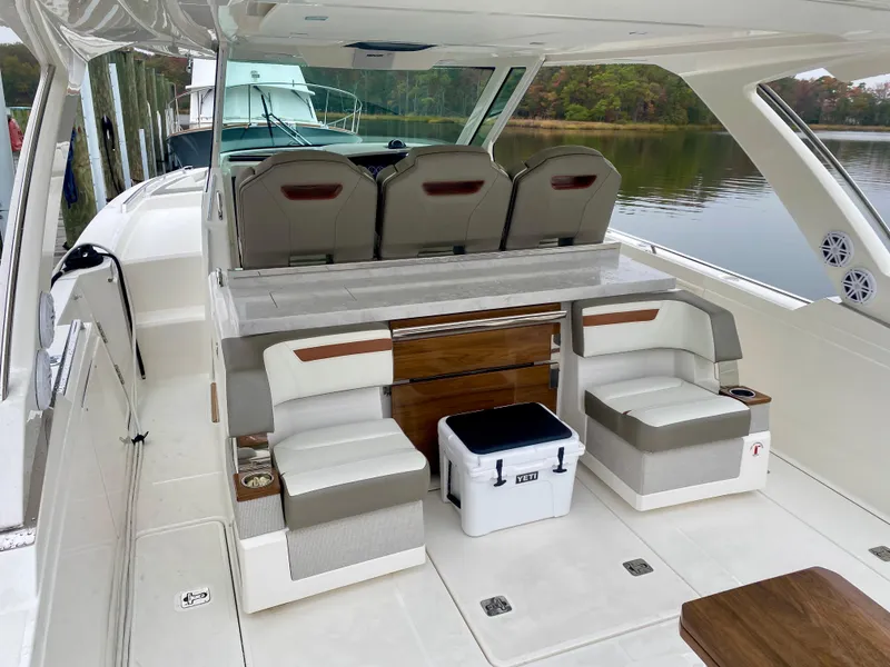 Slide: The Image of 2022 Tiara Yachts 38 LS interior with seating and cooler on a calm lake. - 14