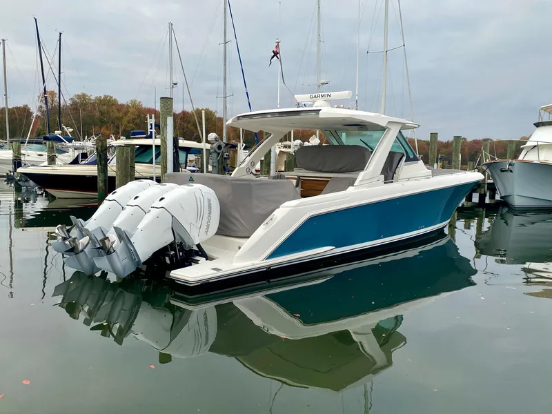 Slide: The Image of 2022 Tiara Yachts 38 LS in marina, featuring triple outboard engines. - 3