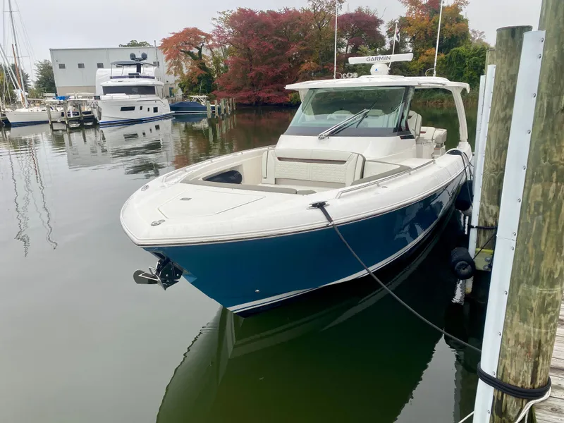 Slide: The Image of 2022 Tiara Yachts 38 LS docked, featuring sleek design and blue hull. - 5