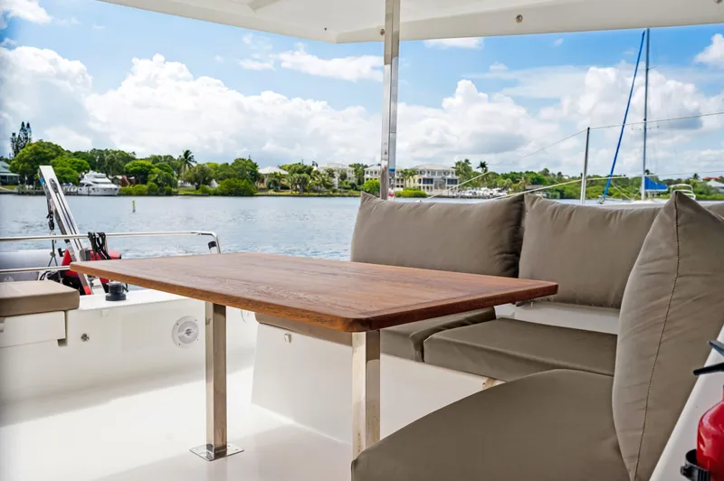 Slide: The Image of Fountaine Pajot Lucia 40 yacht, 2018 model, featuring a cozy outdoor seating area with a wooden table. - 50