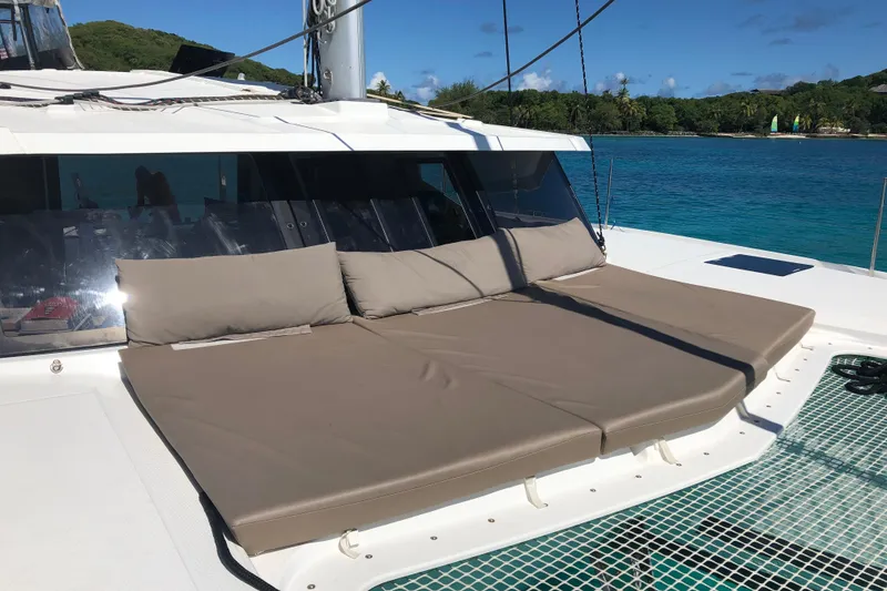 Slide: The Image of Fountaine Pajot Lucia 40 catamaran with sunbathing cushions, anchored near a tropical island, 2018 model. - 59